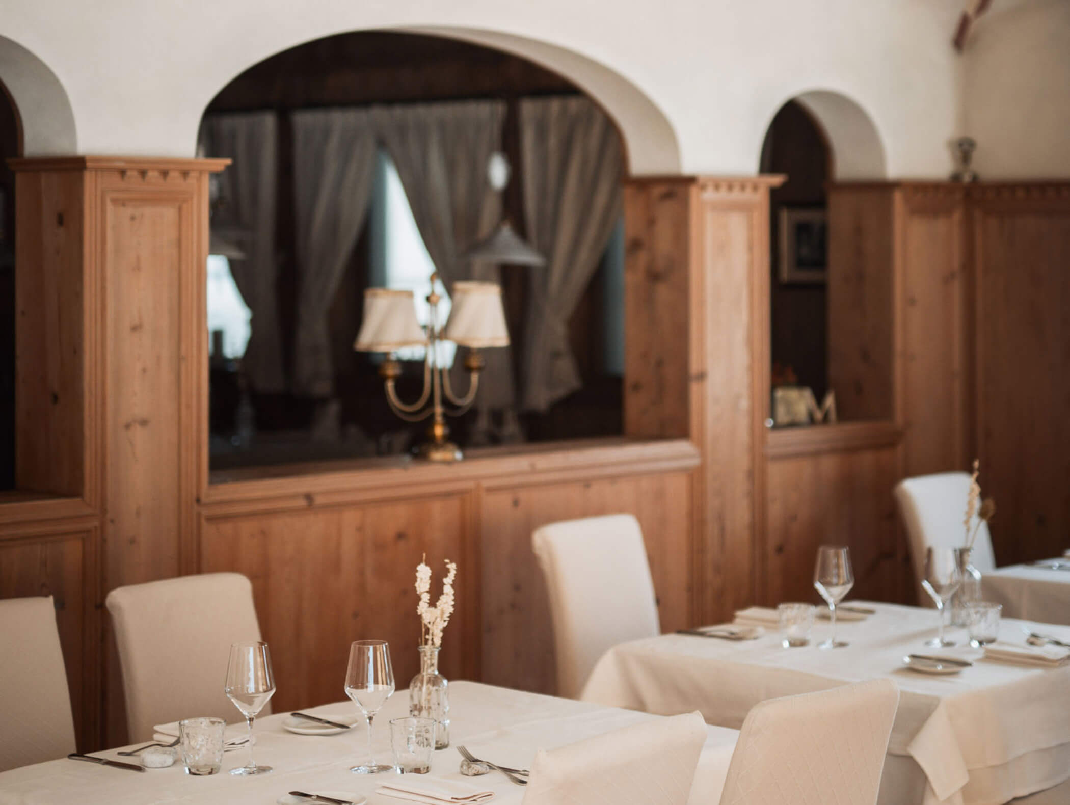 Speisesaal Klosterstube mit Holzboden und -verkleidung und weißen Tischdecken und Stühlen - Hotel Majestic