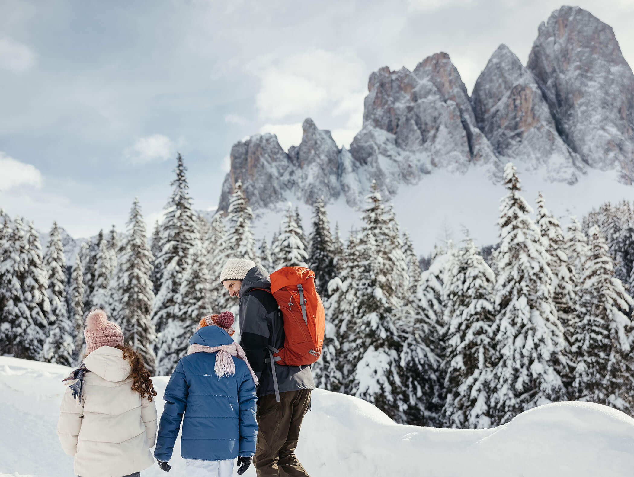 Ein Vater mit seinen Töchtern beim Wandern in den verschneiten Dolomiten - Hotel Majestic